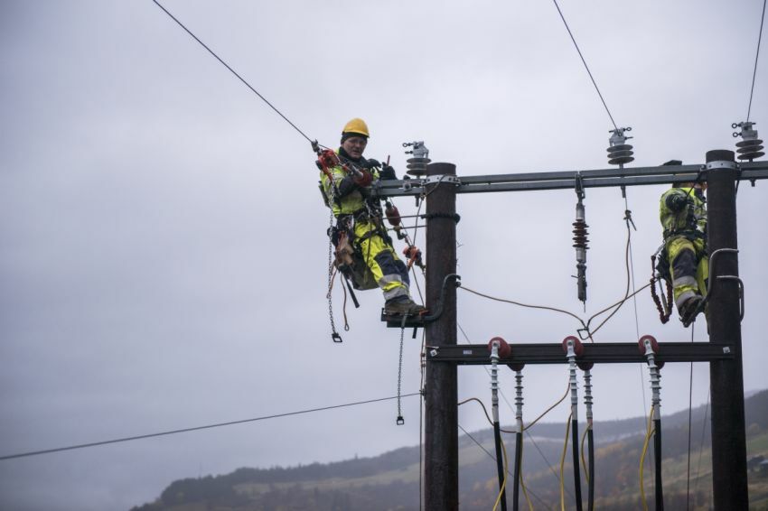 To elektriker jobber på en strømnett linje stolpe